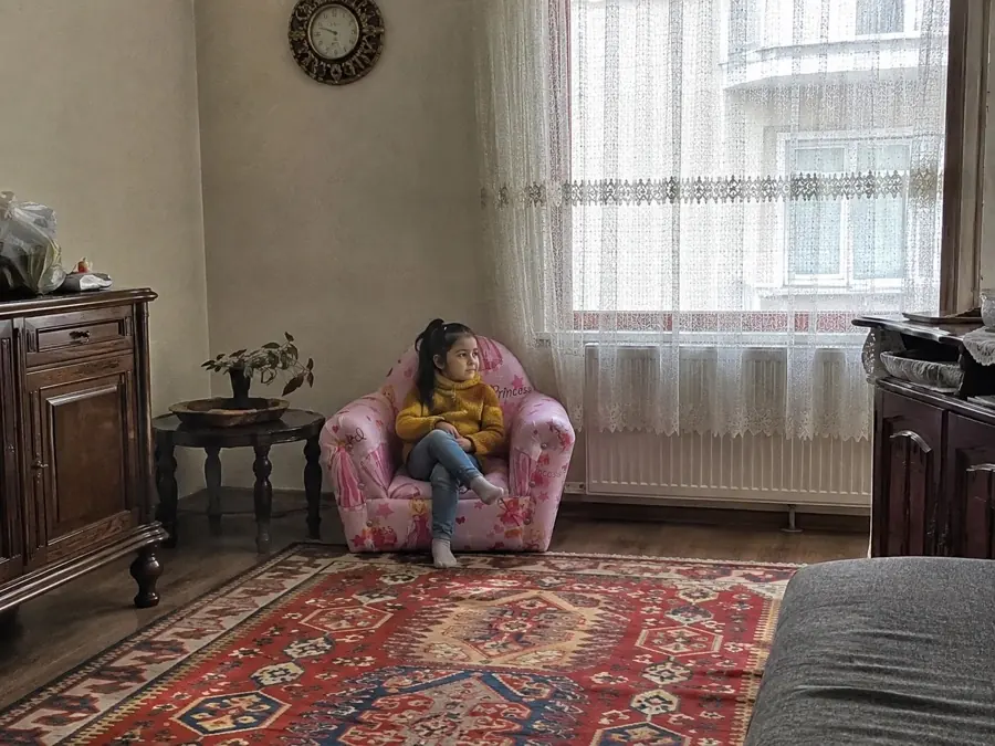 Salonda çocuk koltuğunda oturan kız